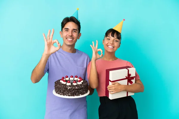 Young Mixed Race Couple Holding Birthday Cake Present Isolated Blue — Stock Photo, Image