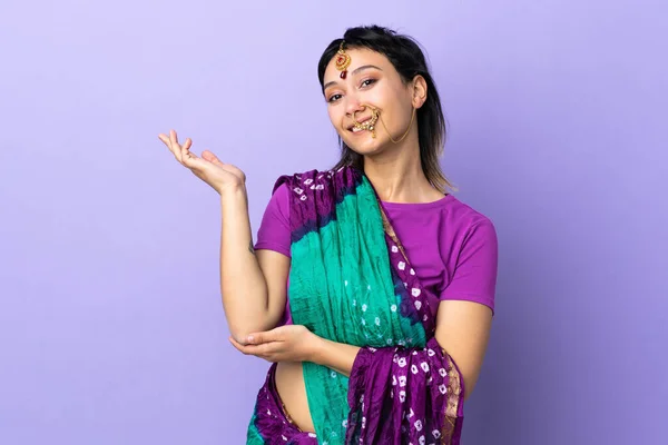 印度妇女被隔离在紫色背景下 向旁边伸出手来邀请她来 — 图库照片