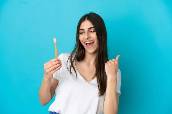 Młoda Biała Kobieta Myje Zęby Odizolowane Niebieskim Tle Świętując Zwycięstwo — Zdjęcie stockowe