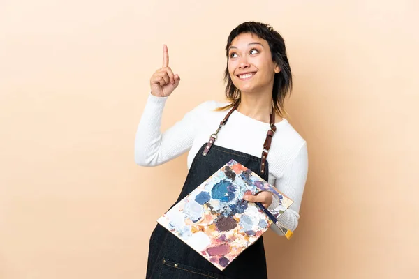 Joven Artista Sosteniendo Una Paleta Sobre Fondo Aislado Señalando Con —  Fotos de Stock