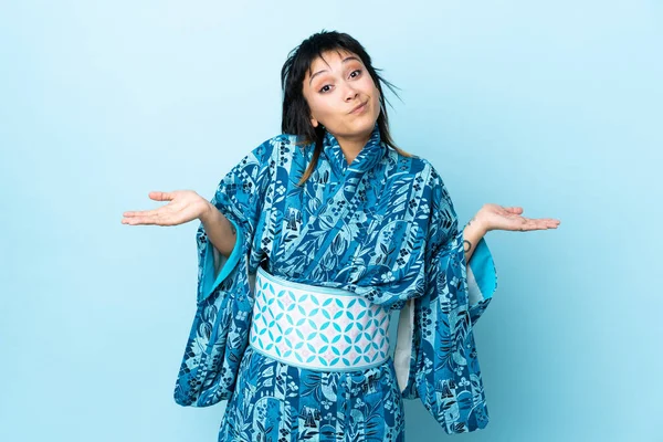 Mujer Joven Que Usa Kimono Sobre Fondo Azul Aislado Que —  Fotos de Stock