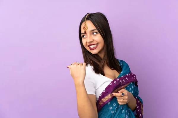 Mujer India Joven Aislada Sobre Fondo Púrpura Apuntando Hacia Lado — Foto de Stock