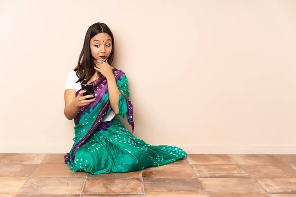 Jeune Indienne Assise Sur Sol Réfléchissant Envoyant Message — Photo
