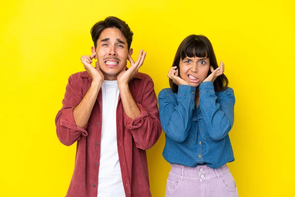 Junges Mischlingspaar Isoliert Auf Gelbem Hintergrund Beide Ohren Mit Händen — Stockfoto