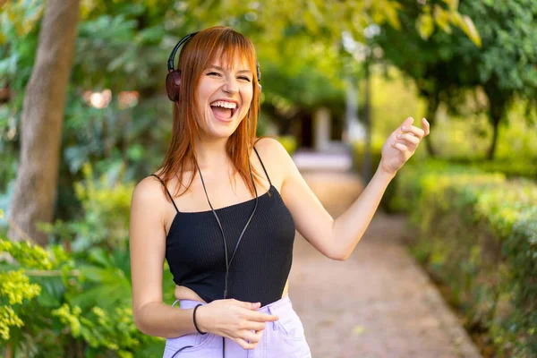 Молодая Красивая Рыжая Женщина Открытом Воздухе Слушает Музыку Делает Гитарный — стоковое фото