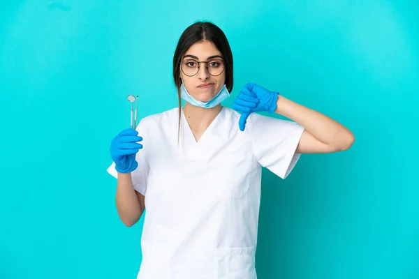 Νεαρή Καυκάσια Οδοντίατρος Κρατώντας Εργαλεία Απομονωμένα Μπλε Φόντο Που Δείχνουν — Φωτογραφία Αρχείου
