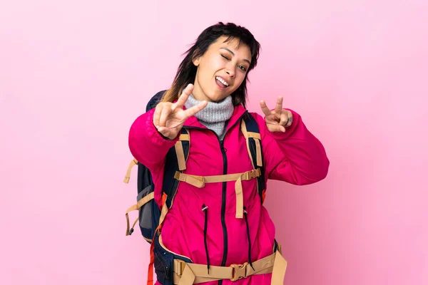 Молодая Альпинистка Большим Рюкзаком Изолированном Розовом Фоне Улыбается Показывает Знак — стоковое фото