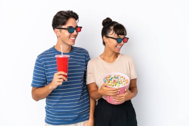 Beyaz arka planda 3 boyutlu gözlüklü ve elinde koca bir kova patlamış mısırla gezen melez arkadaşlar.