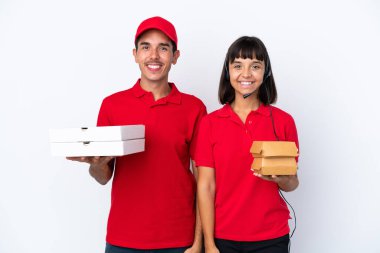 Beyaz arka planda pizza ve hamburger tutan genç teslimatçı çift kollarını kalçalarına dayayıp gülümsüyor.