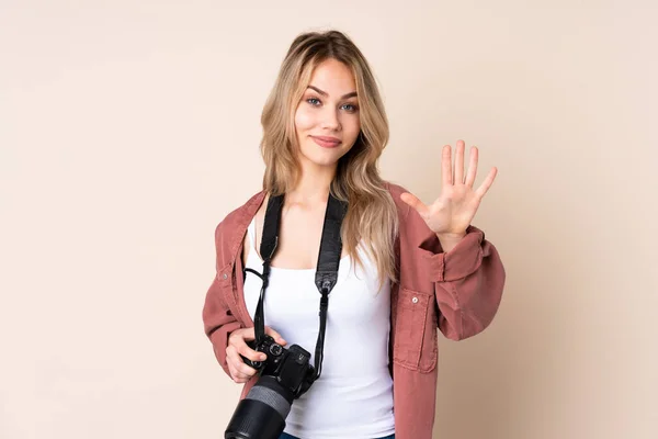 独立背景的年轻摄影师女孩用手指数着5 — 图库照片