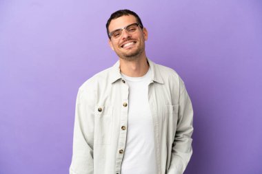 İzole edilmiş mor arka planda gülen Brezilyalı bir adam