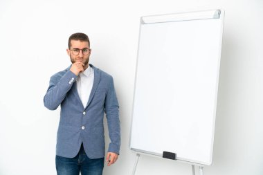 Beyaz arka planda izole edilmiş beyaz panoda sunum yapan genç iş kadını