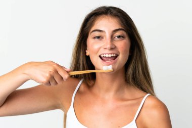 Beyaz arka planda diş fırçası ve mutlu bir ifadeyle izole edilmiş beyaz bir beyaz kadın.