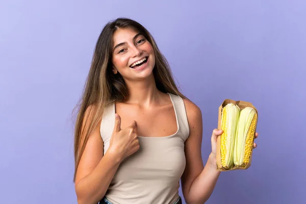 Jovem Segurando Milho Isolado Fundo Roxo Com Expressão Facial Surpresa — Fotografia de Stock