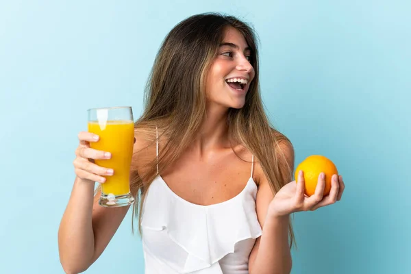 Ung Kaukasisk Kvinna Isolerad Blå Bakgrund Håller Apelsin Och Apelsinjuice — Stockfoto