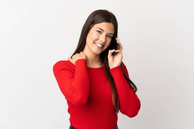 İzole edilmiş beyaz arka planda cep telefonu kullanan Brezilyalı genç kız gülüyor.