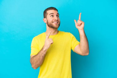 Mavi arka planda izole edilmiş yakışıklı beyaz adam işaret parmağıyla işaret etmek harika bir fikir.