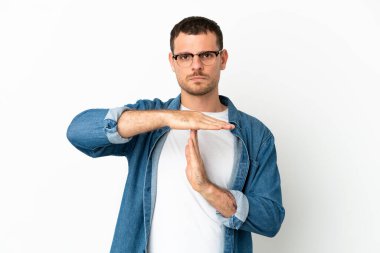 İzole edilmiş beyaz arka planda Brezilyalı bir adam zaman aşımı hareketi yapıyor.