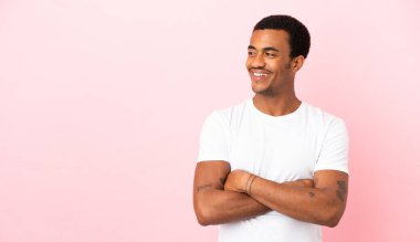 Telif uzayındaki Afrikalı Amerikalı adam pembe arka planda mutlu ve gülümsüyor