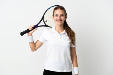 Beyaz arka planda tenis oynayan beyaz tenli genç kadın.