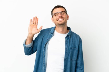 Brezilya 'lı erkek izole edilmiş beyaz arka planda mutlu bir ifadeyle selamlıyor.