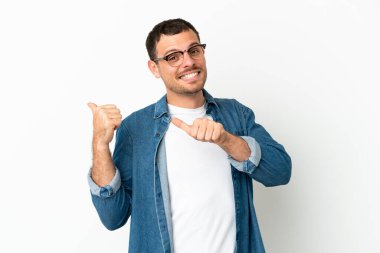 İzole edilmiş beyaz arka plan üzerinde Brezilyalı bir adam bir ürün sunmak için kenarı işaret ediyor