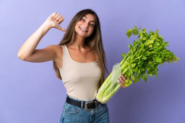 Mor arka planda kendini beğenmiş ve gururlu bir kereviz tutan genç kadın.