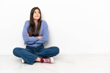 Açık kat yapma oturan genç kadın omuz kaldırma sırasında jest şüpheler