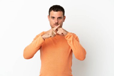 İzole edilmiş beyaz arka plan üzerinde Brezilyalı bir adam sessizlik işareti gösteriyor.