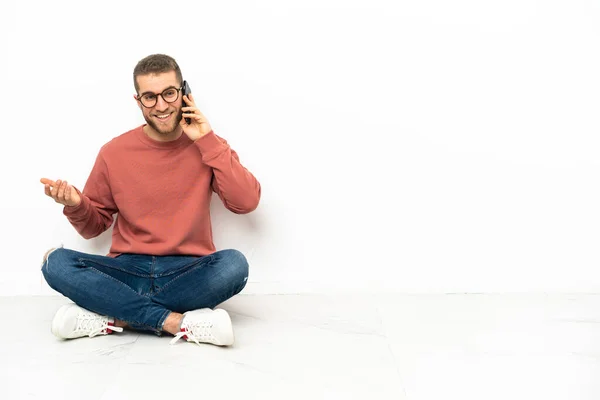 Mladý Pohledný Muž Sedí Podlaze Někým Povídá Mobilním Telefonem — Stock fotografie
