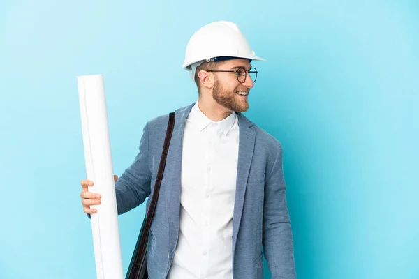 Giovane Architetto Uomo Con Casco Tenendo Cianografie Sfondo Isolato Cercando — Foto Stock