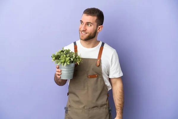 Gardener Caucasian 바라보고 웃으면서 배경에 고립된 식물을 — 스톡 사진