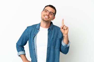 İzole edilmiş beyaz arka plan üzerinde Brezilyalı bir adam en iyinin işareti olarak parmağını kaldırıyor.