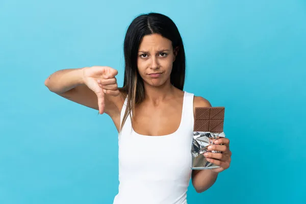 Kavkazská Dívka Izolované Modrém Pozadí Čokoládovou Tabletu Dělat Špatný Signál — Stock fotografie