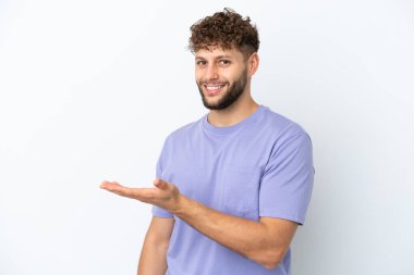 Beyaz arka planda izole edilmiş yakışıklı beyaz adam gülümserken bir fikir sunuyor.