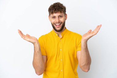 Beyaz arka planda izole edilmiş yakışıklı beyaz adam şok olmuş yüz ifadesi ile