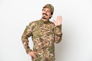 Beyaz arka planda izole edilmiş asker mutlu bir ifadeyle selamlıyor.
