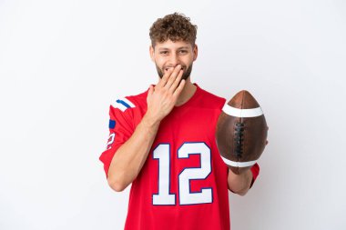 Beyaz arka planda ragbi oynayan genç beyaz adam mutlu ve gülümsüyor.