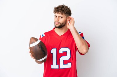 Beyaz arka planda ragbi oynayan Kafkasyalı genç adamın şüpheleri var.