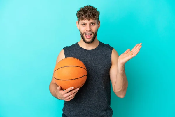 Guapo Joven Jugando Baloncesto Aislado Sobre Fondo Azul Con Expresión —  Fotos de Stock