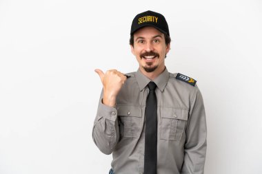 Beyaz arka planda izole genç beyaz güvenlik elemanı bir ürün sunmak için kenarı işaret ediyor
