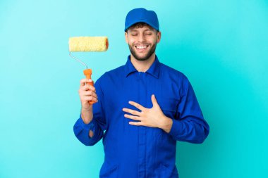 Kafkasyalı ressam, mavi arka planda izole edilmiş, gülümsüyor.