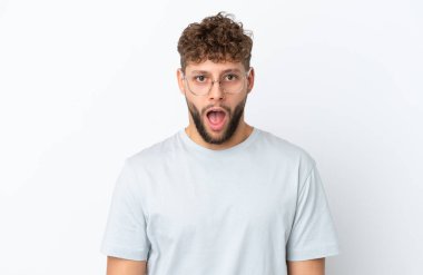 Beyaz arka planda gözlüklü ve şaşkın bakışlı yakışıklı beyaz bir adam.