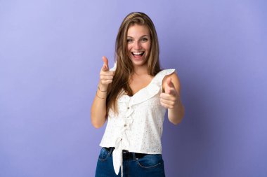 İzole edilmiş geçmişi olan beyaz bir kadın şaşırmış ve ön tarafı işaret ediyor.