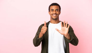 Telif uzayındaki Afrikalı Amerikalı adam pembe arka planda parmakları olan altı kişi sayıyor