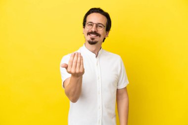 Sarı arka planda izole edilmiş genç beyaz bir adam, bizimle gelmesi için davet ediyor. Gelmene sevindim.