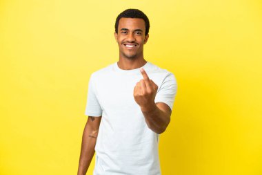 Sarı arka planda Afro-Amerikalı yakışıklı bir adam geliyor.