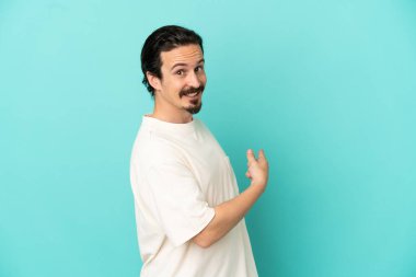 Kafkasyalı genç adam mavi arka planda izole edilmiş.