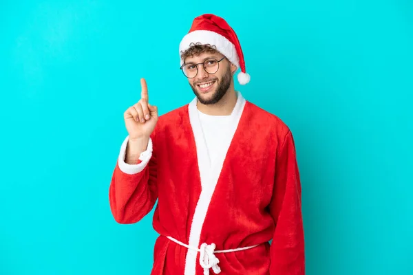 Ung Man Förklädd Till Jultomten Isolerad Blå Bakgrund Visar Och — Stockfoto