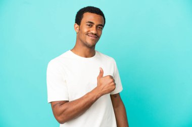 İzole edilmiş mavi arka planda, gururlu ve kendini beğenmiş Afro-Amerikan yakışıklı adam.